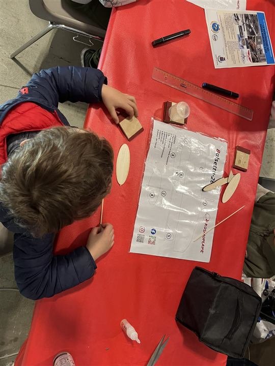 Un ragazzo costruisce il suo aereo al tavolo del laboratorio